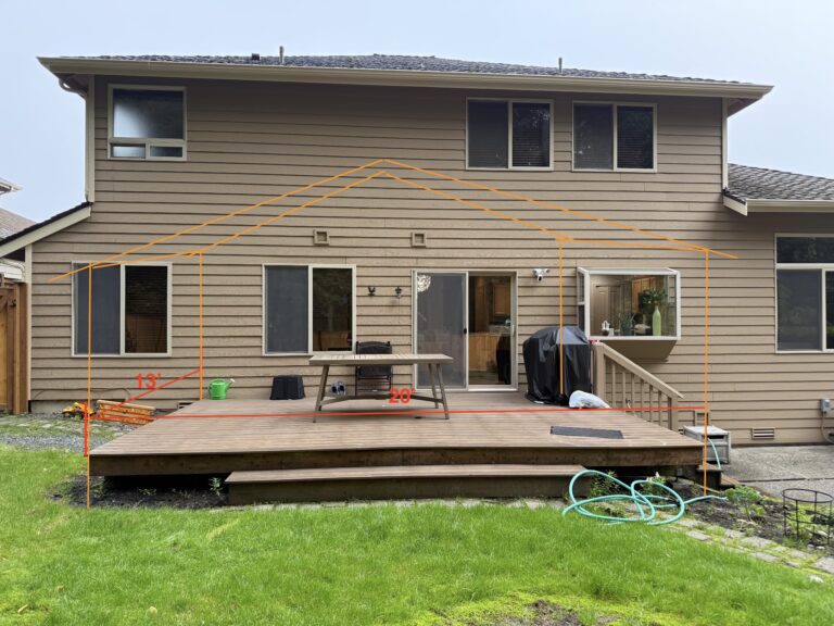 Rear of two-story Tacoma home with orange chalk sketch outlining a planned covered gable extension above the deck