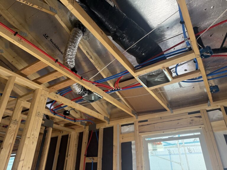 Ceiling framing with PEX lines, HVAC flex duct and TechShield radiant-barrier roof sheathing above