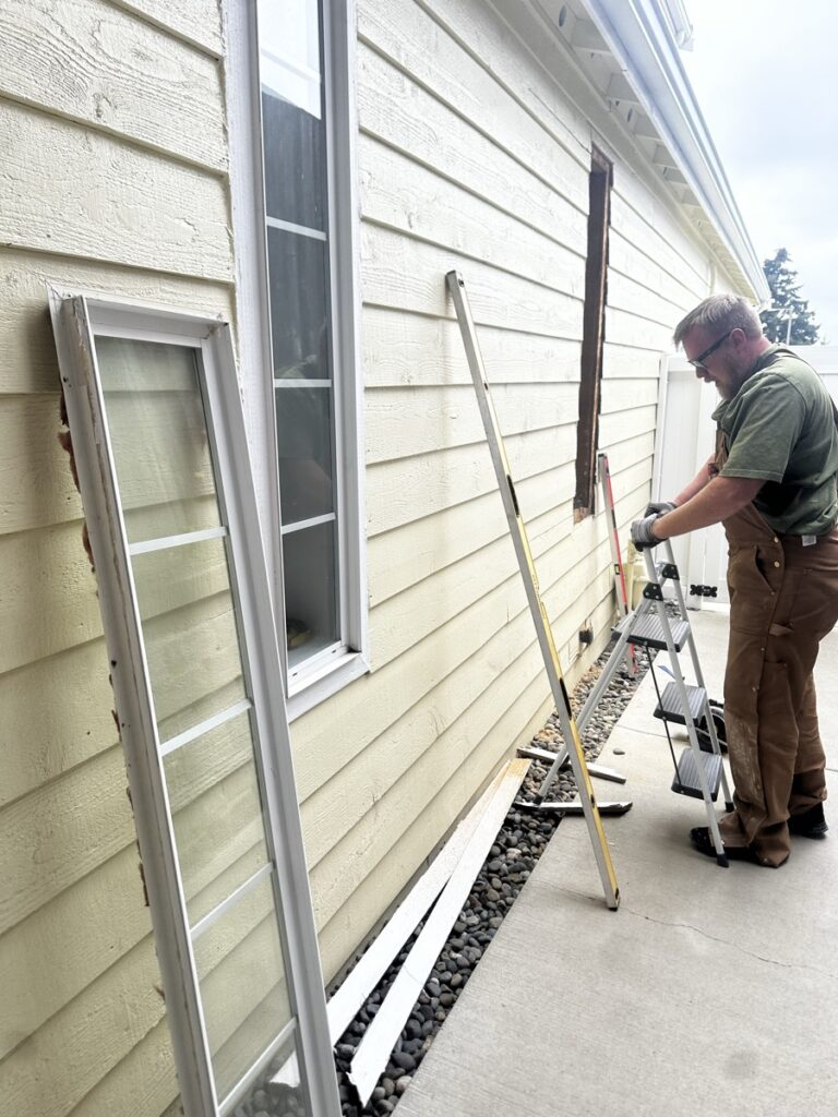 Contractor replacing exterior windows on an adult family home in Tacoma during energy upgrade