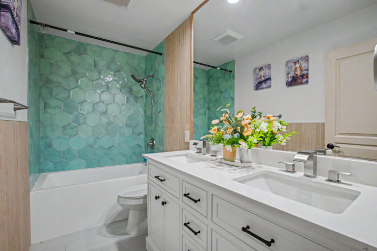 Guest bathroom remodel with emerald green hexagon tile tub surround, shaker double vanity and quartz countertop