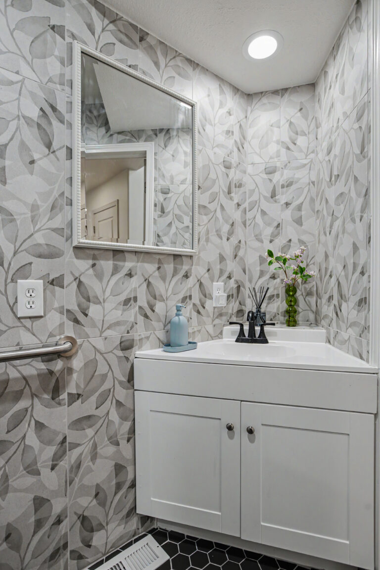 Accessible bathroom vanity with black fixtures, wall-mounted mirror and grab bar for an Adult Family Home